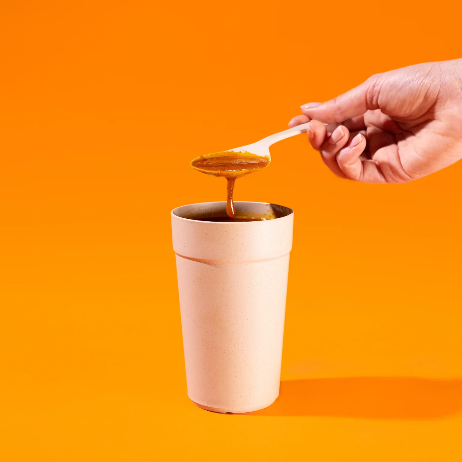 Cup met soep en hand